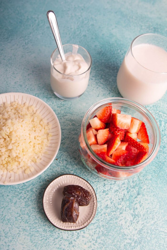 frasco con fresas, yogur, leche de almendra y coliflor rallada