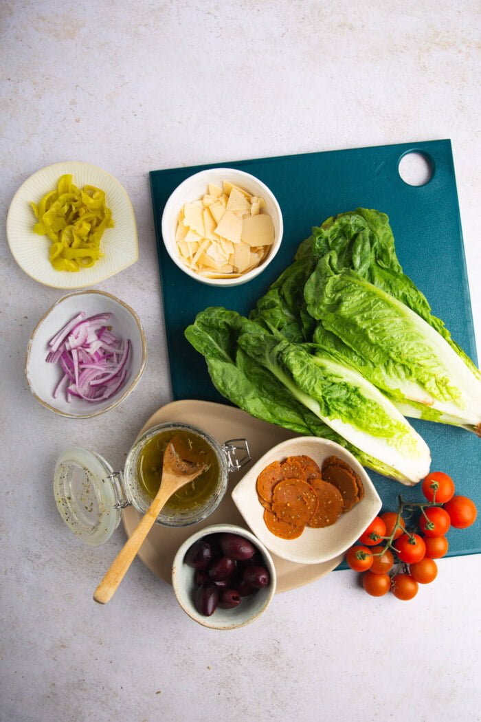 LEchugas romaansa, tomates cherry, queso peperoni, aceitunas y aderezo para ensalada italiana.