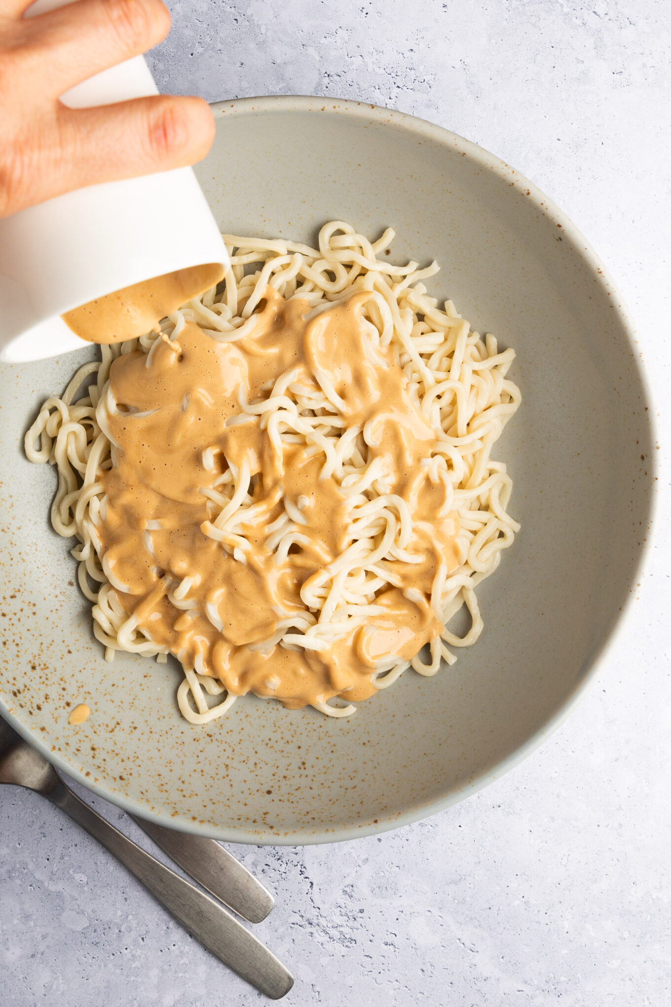 Verter el aliño casero picante de anacardos en un bol con fideos sin gluten