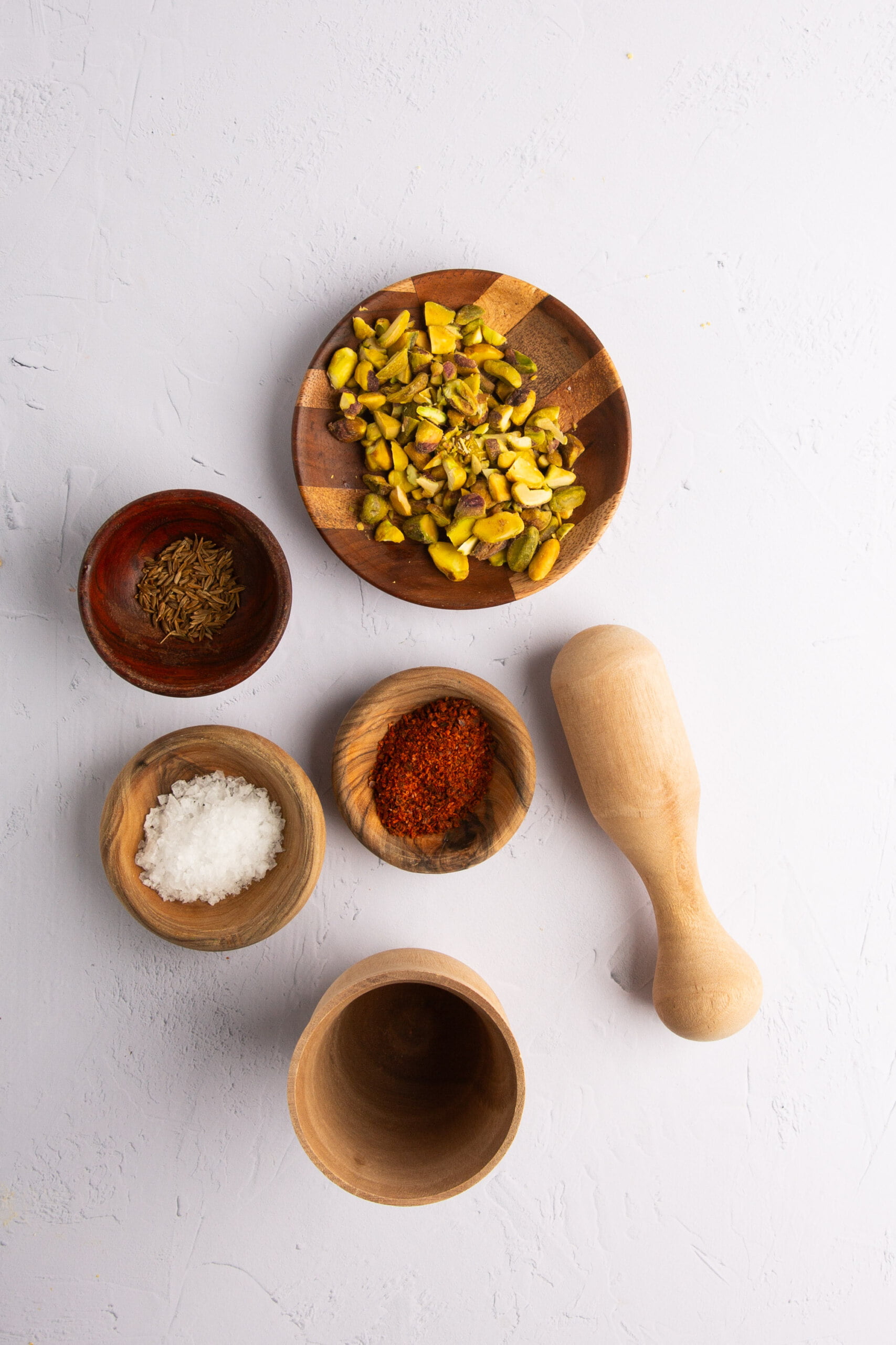 Platitos pequeños con pistaches, semillas de sésamo, comino y flores comestibles para decorar hummus.