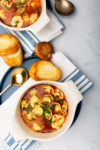 Dos tazones de sopa saludable con pan en una mesa.