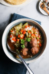 Un plato de sopa vegana con albóndigas y verduras.