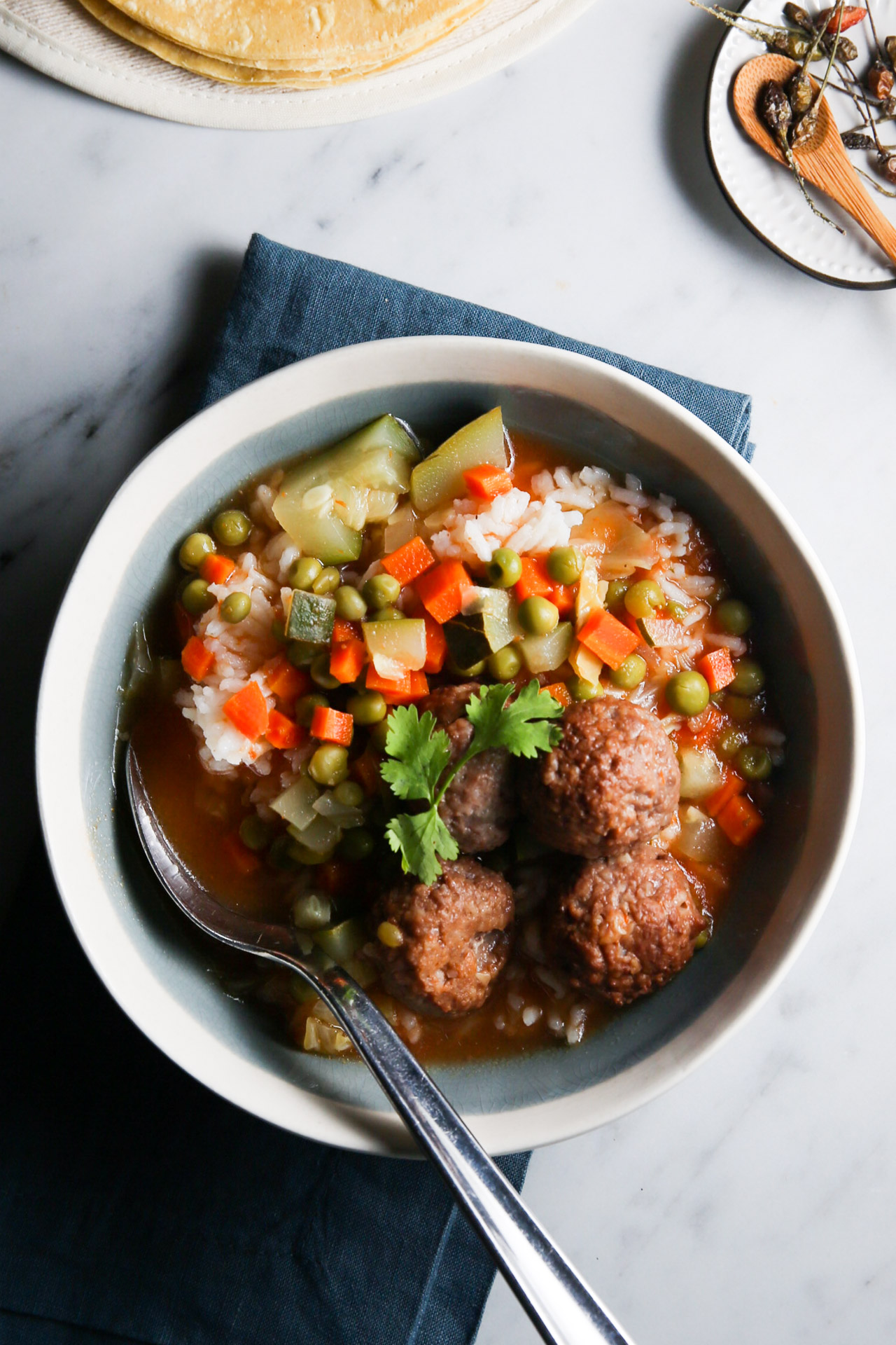 Un plato de sopa vegana con albóndigas y verduras.