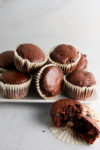 Automatic eraser, chocolate muffins on a white plate with a bite taken out.