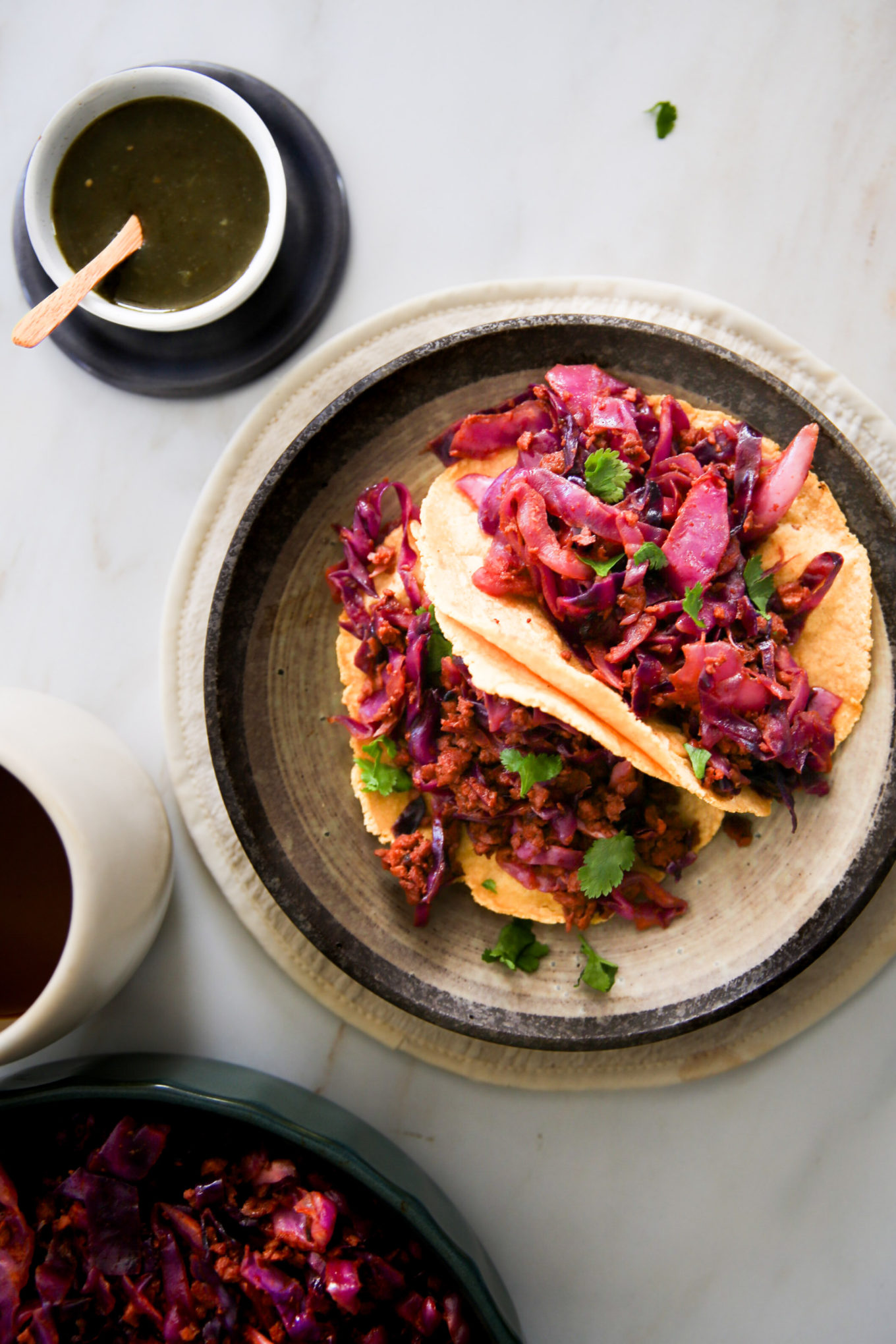 Tacos de col roja en un plato con una taza de café.