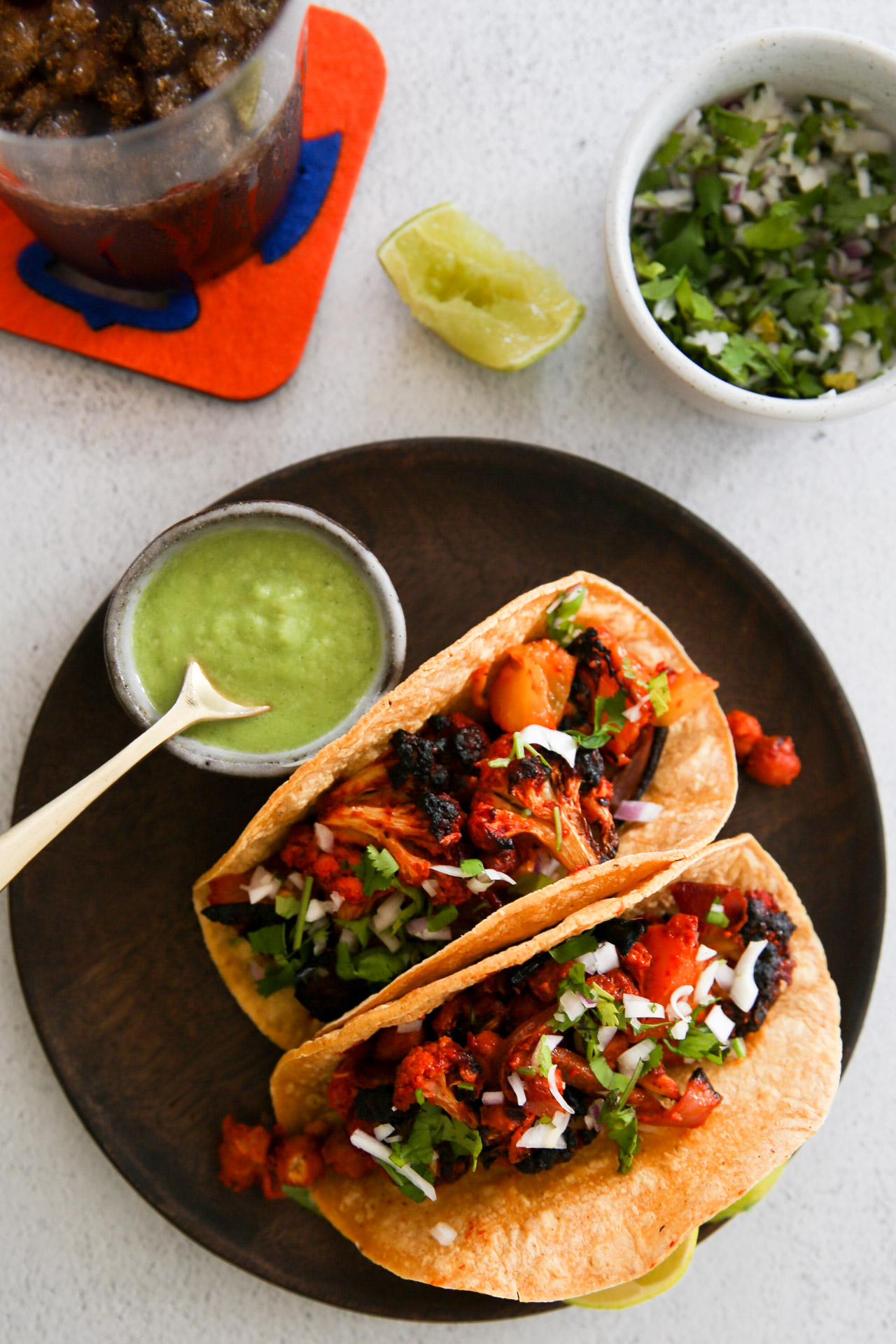 Dos tacos en un plato junto a un plato de guacamole.