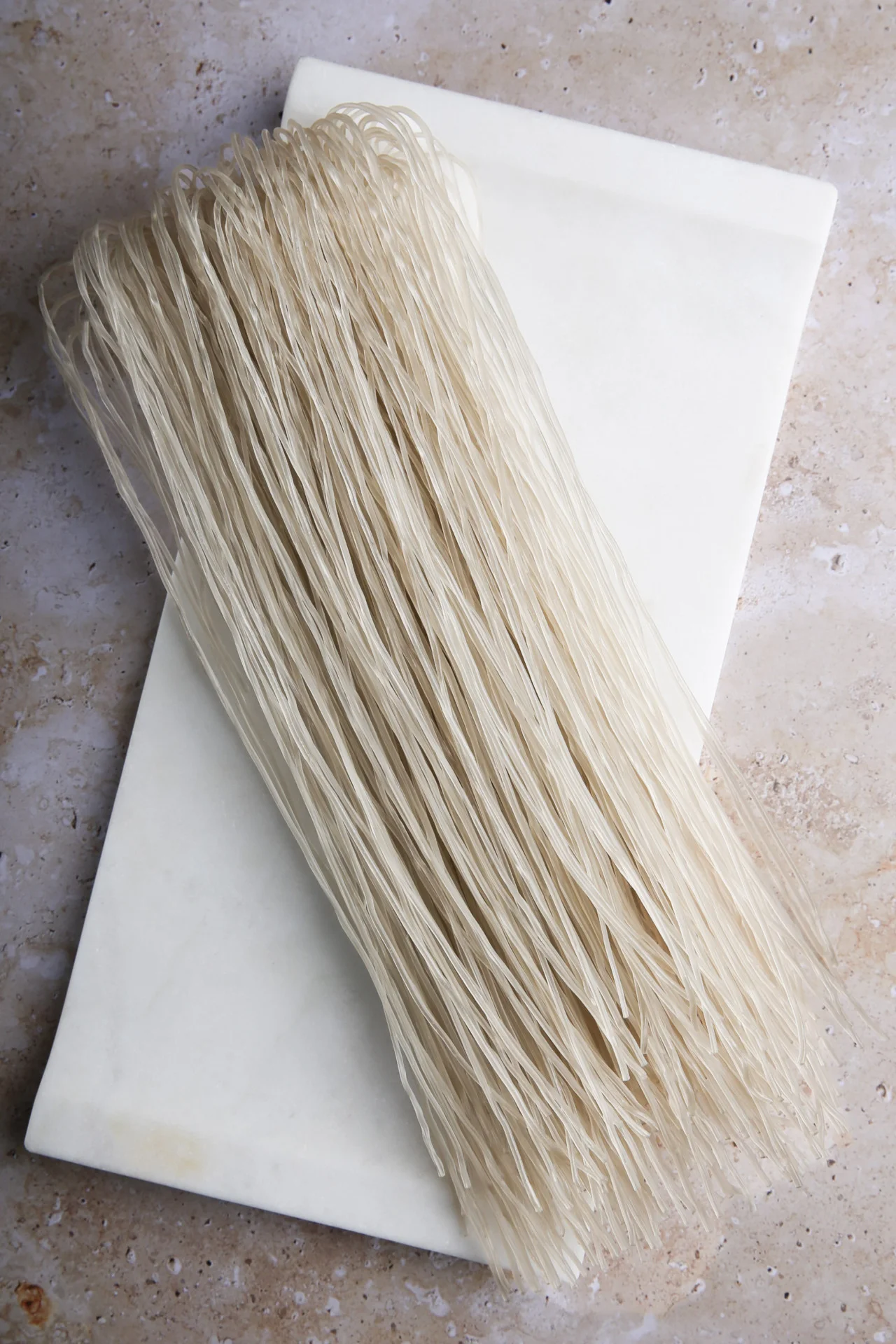 Fideos de cristal coreanos sin cocer sobre una tabla de m&aacute;rmol blanca